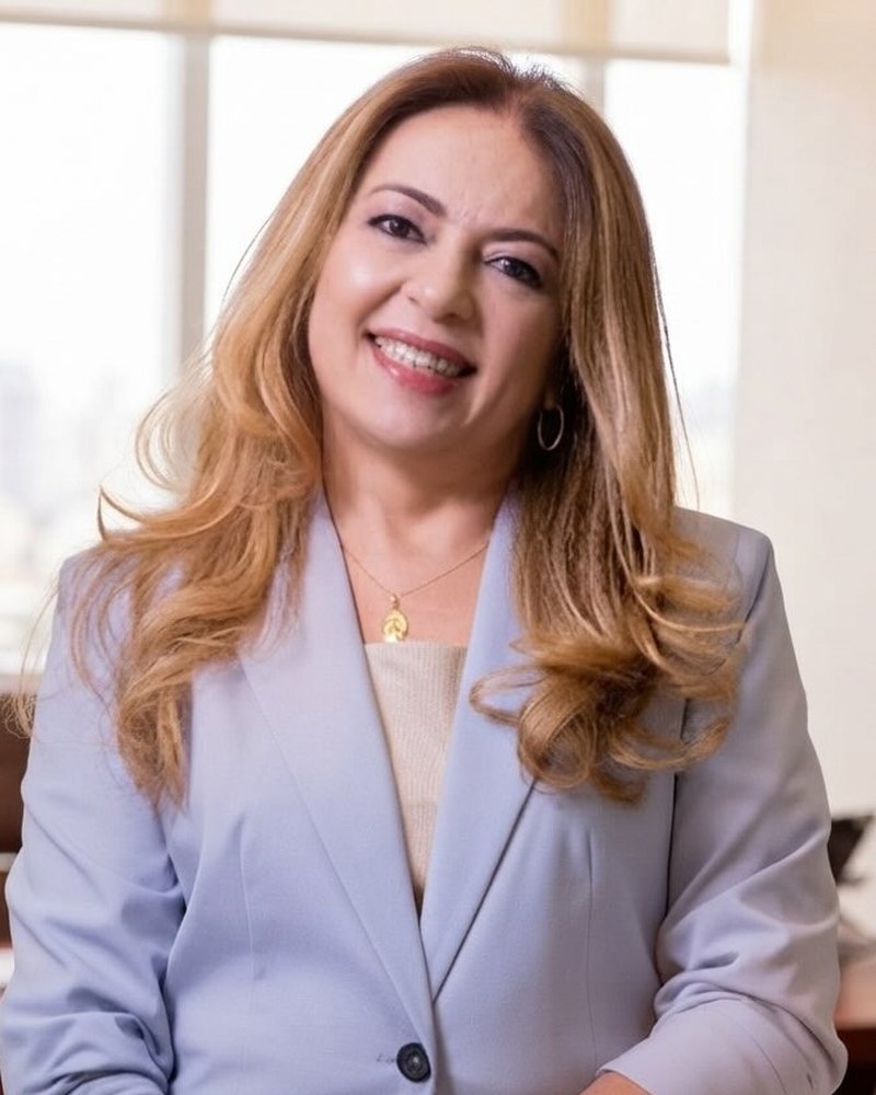 A advogada Andréa Rebêlo no escritório, de blazer azul-claro